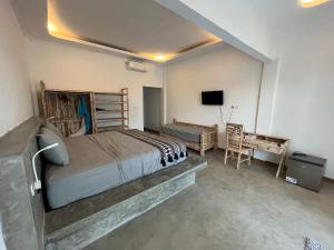 a bedroom with a bed and a desk and a television at Sanctum Hotel and Dive- Nusa Penida in Nusa Penida