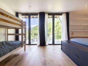 een slaapkamer met een stapelbed en een groot raam bij Maison Grust, 5 pièces, 12 personnes - FR-1-402-110 in Grust