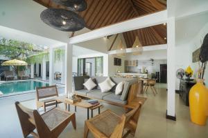 an open living room with a couch and a table at SunGlow Villa in Seminyak