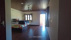 a bedroom with a bed and a wooden floor at Nayar Valley Retreat in Lansdowne