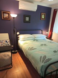 1 dormitorio con 1 cama con pared azul en Kincumber Guest Suite, en Kincumber