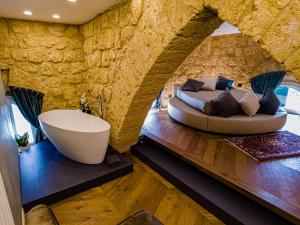 een slaapkamer met een groot bed en een bad bij A casa di Mammì nella Valle dei templi in Agrigento