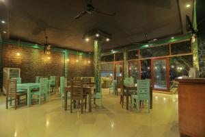 a restaurant with tables and chairs and a brick wall at Woodnest Summerside in Negombo