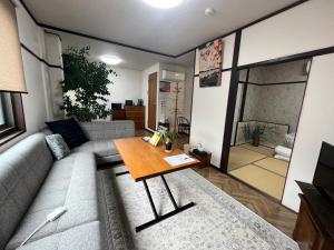 un soggiorno con divano e tavolo di Old modern house in Nara Second a Nara