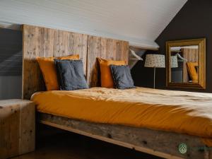 a bedroom with a large bed with a wooden headboard at Forest Cottage Near Leenderbos in Leende