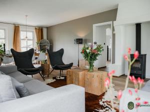 uma sala de estar com um sofá e uma mesa com flores em Authentic Holiday Home in North Brabant by the Forest em Leende