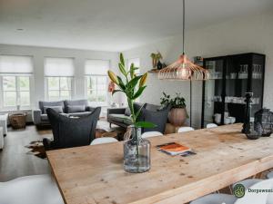 uma sala de estar com uma mesa de madeira com um vaso sobre ela em Authentic Holiday Home in North Brabant by the Forest em Leende