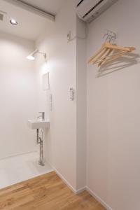 a bathroom with white walls and a sink at CASA Kamakura Espresso&BED in Kamakura