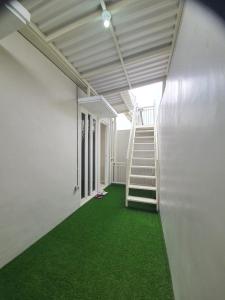 巴圖的住宿－Villa Bahari Batu，客房内设有楼梯和绿色地毯。
