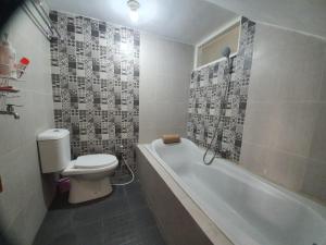 ein Badezimmer mit einem WC und einer Badewanne in der Unterkunft Villa Bahari Batu in Batu