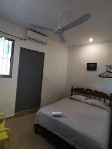 una camera con letto e ventilatore a soffitto di La casita del árbol, amplia y cómoda en barrio familiar a Campeche