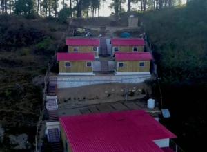 uma vista aérea de uma casa com telhados vermelhos em Secret Staycation Nature Cottages em Kandāghāt