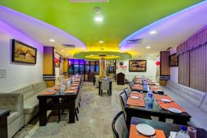 a dining room with long tables and a green ceiling at Crystal Paark Inn By Blu Orchid Group in Mysore