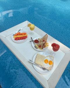 曼德倫的住宿－La Vera Boutique Hotel, Mandrem，游泳池旁的餐桌上摆放着食物和饮料