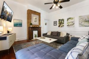a living room with a blue couch and a fireplace at Uptown Spacious 4BD/3BA with Historic Charm in New Orleans