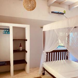 a bedroom with a bed with a canopy at Cafe Ceylon in Koggala