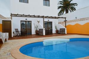 a swimming pool in front of a house at Casa la Ermita in Máguez
