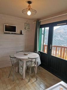 a dining room with a table and chairs and a window at Studio vue montagne proche des pistes in Orcières