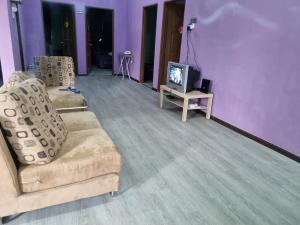 uma sala de estar com duas cadeiras e uma televisão em E.R. BUDGET INN em Kota Bharu