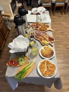 una mesa con muchos platos de comida. en Casa OLD BRICK, en Ocna Şugatag