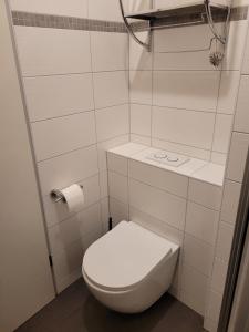 y baño blanco con aseo y ducha. en Haus Sachsensteinblick Ferienwohnung Sonnenschein, en Bad Sachsa