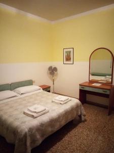 1 dormitorio con cama, espejo y ventilador en B&B SILVANO, en Bolonia