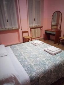 1 dormitorio con 1 cama grande y 2 toallas. en B&B SILVANO, en Bolonia