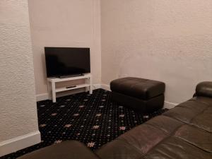 a living room with a couch and a flat screen tv at Bright 3 Bedroom Edinburgh City Apt in Edinburgh