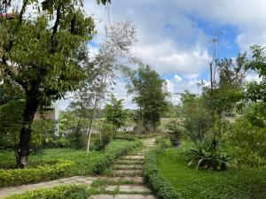 un camino en un jardín con árboles y arbustos en Son Home Garden en Hue