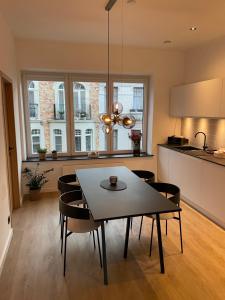 una cucina e una sala da pranzo con tavolo e sedie di Cabine Congé nieuw appartement dichtbij zee a Ostenda