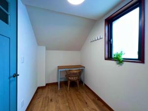 an attic room with a table and a window at HONRENGA石垣島 in Ishigaki Island