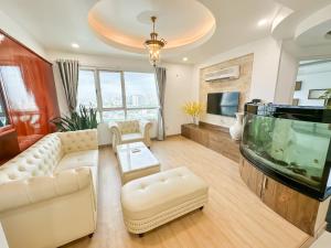 a living room with a couch and a fish tank at White Penthouse-Rooftop Pool Private -Central City in Ho Chi Minh City