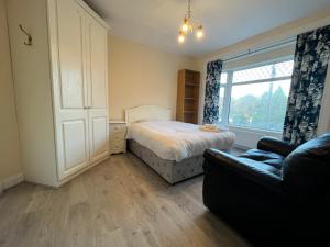 a bedroom with a bed and a couch and a window at The D3 Self Catering in Dublin