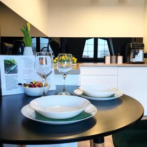 stół z dwoma kieliszkami i miską jedzenia w obiekcie Apartament Bianco Verde w mieście Częstochowa