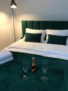 łóżko z butelką piwa i 2 kieliszkami do wina w obiekcie Apartament Bianco Verde w mieście Częstochowa