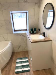 łazienka z umywalką i lustrem w obiekcie Apartament Bianco Verde w mieście Częstochowa