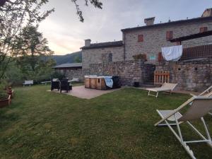 un cortile con sedie e un edificio in pietra di Alpe di Sara a Fiumalbo