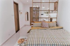 a bedroom with a large bed with a plaid blanket at Yody Homestay Ocean Park, Gia Lâm, Hà Nội in Hanoi