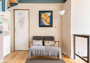 ボルドーにあるDuplex-terrasse-parking-climatisationのベッドと壁に絵が飾られた寝室