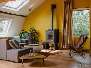 uma sala de estar com um sofá e uma lareira em Vibrant Farmhouse near Forest in Heeze-Leende em Leende