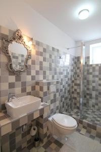 ein Badezimmer mit einem WC, einem Waschbecken und einem Spiegel in der Unterkunft Vila Sibiu in Sibiu
