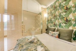 a bedroom with a large bed with a floral wallpaper at Superbe studio apartment à 2MN de Paris in Gentilly