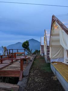 a group of tents with mountains in the background at Tukadsari camping in Kintamani