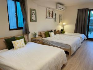 1 Schlafzimmer mit 2 Betten und einem Sofa in der Unterkunft 出水茶旅民宿 in Zhuqi