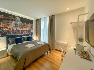 een slaapkamer met een groot bed en een televisie bij Bed-da Catania Rooms in Catania