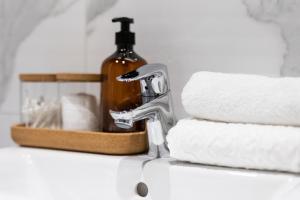 a bathroom sink with a bottle of soap and towels at Arctic Night City Suite in Rovaniemi
