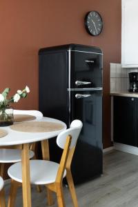 a black refrigerator in a kitchen with a table at Arctic Night City Suite in Rovaniemi