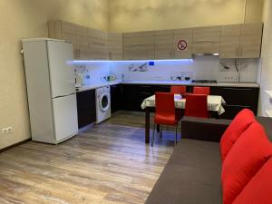 a kitchen with a table and a white refrigerator at 2-х комн квартира в новом элитном доме в центральном районе города in Cherkasy