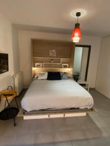- une chambre avec un grand lit et une tête de lit en bois dans l'établissement Studio Chic Little Bohême 40 mn du stade olympique, à Lyon