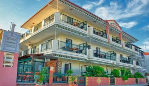 a large white building with balconies on a street at Apartmenthotel Sithon in Sarti